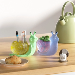 Detail of snail-shaped resin organizers used as a pen holder and succulent planter
