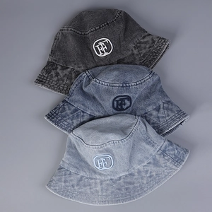 Gros plan de trois bobs en denim délavé vintage avec broderie FF en différentes couleurs