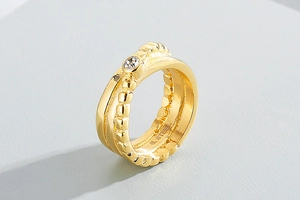 Macro shot of gold stainless steel ring with crystal and G.STEEL engraving