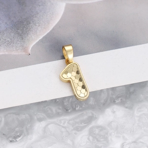 Macro shot of gold number 1 pendant featuring a hammered texture and polished metal border