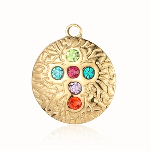 Macro view of gold stainless steel round pendant with colorful embedded gemstones