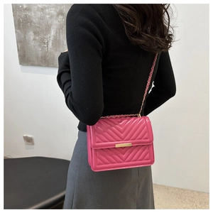 Pink V-quilted small square bag with gold chain strap worn by model from behind