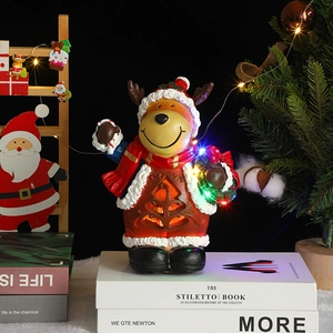 Detail of resin Christmas reindeer decoration with internal LED lights and festive scarf