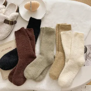 Thick winter plush socks in five colors on a soft white carpet with home decor