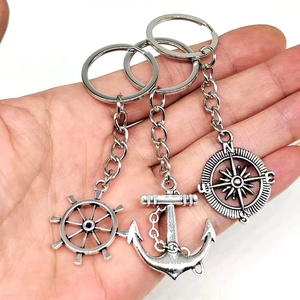Detail of vintage silver nautical charms including anchor, rudder and compass for keychains