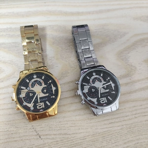 Close-up of gold and silver business quartz watches with metal straps on wooden table