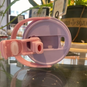 Detail of pink and purple split-color insulated cup lid with convenient flip handle
