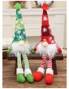 Close-up of red and green Christmas gnomes with knitted hats sitting on a wooden stool