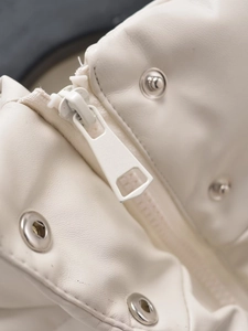 Macro detail of high-quality white leather fabric with metallic zipper and snap button