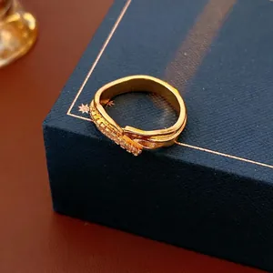 Bague vague plaquée or irrégulière avec zircons sur boîte à bijoux bleue