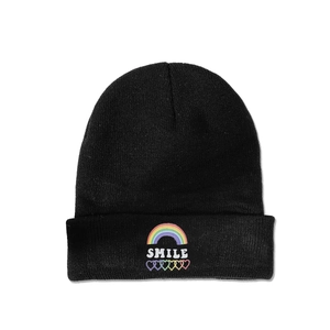 Detailed close-up of rainbow and smile embroidery on a black knitted winter beanie