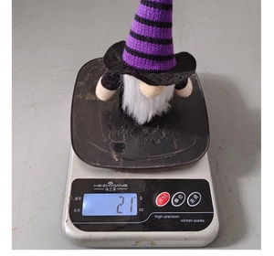 Close-up showing the 21g lightweight measurement of a Halloween gnome plush doll
