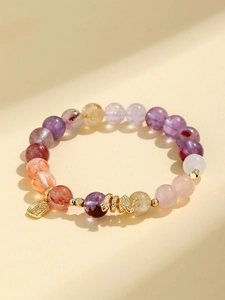 Macro shot of colorful crystal bead bracelet with a gold snake charm and lucky pendant