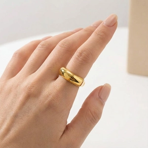 Close-up of minimalist 18k gold plated dome ring with polished mirror surface