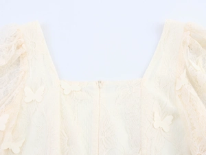 Detailed macro view of 3D butterfly appliqués on elegant square neck lace blouse