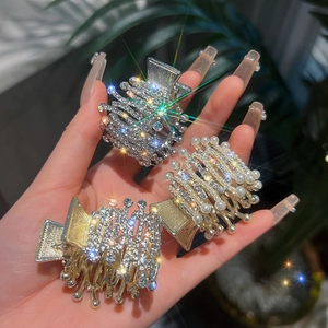 Gros plan sur des barrettes en strass et perles pour fixer une queue de cheval haute