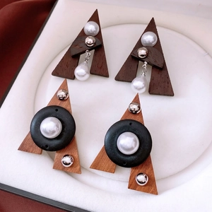 Retro triangle wood and pearl drop earrings displayed in a luxury white jewelry case