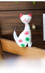 Detailed view of hand-painted floral patterns on a Nordic white wooden cat sculpture