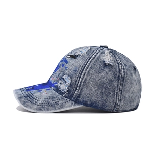 Vintage washed blue denim baseball cap featuring hand-painted graffiti and distressed holes