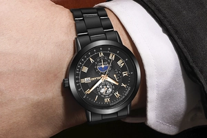 Primo piano dell'orologio nero con fasi lunari e numeri romani dorati al polso uomo
