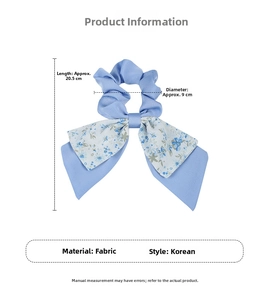 Detail of light blue floral scrunchie with long bow ribbon made of soft chiffon fabric