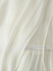 Dettaglio in primo piano del tessuto in chiffon avorio con trama verticale e cuciture