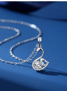 Macro shot of silver swan necklace pendant with sparkling moissanite stones