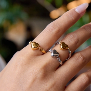 Eleganter goldener Herz-Ring aus Edelstahl an der Hand einer Frau im Freien gezeigt