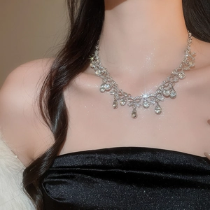 Detailed close-up of a luxury silver teardrop crystal necklace worn by a model