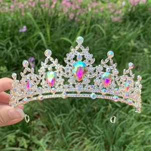 Detail of silver bridal crown with iridescent rhinestones held against a nature backdrop