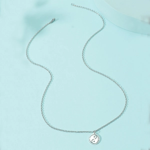 Detailed macro view of silver compass Tai Chi pendant with a fine O-link steel chain