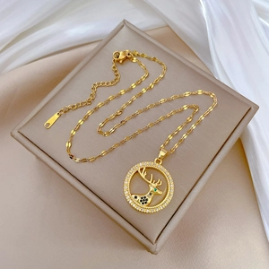 Elegant gold titanium necklace featuring a deer head pendant with sparkling zircons on jewelry box