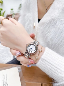 Détail d'une montre en acier bicolore avec chiffres romains et bracelet étoile