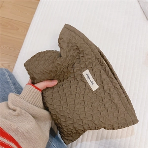 Gros plan détaillé de la trousse de toilette plissée vert olive avec étiquette tissée