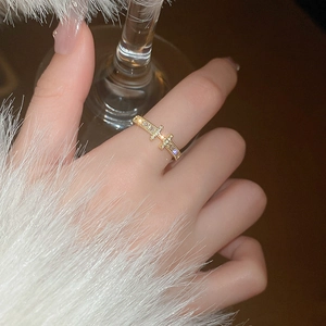 Detail of gold-plated open ring with shimmering zircons worn on a fuzzy white sleeve