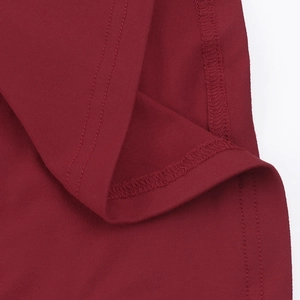 Gros plan sur la texture du tricot bordeaux et les coutures intérieures de la robe