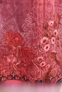 Close-up of ethnic floral print fabric with red roses and delicate lace textures