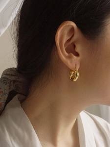 Detail shot of chunky gold hoop earrings with detachable natural pearl drops on model