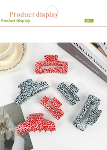 Flat lay of leopard print hair claw clips in red and blue grey on white background