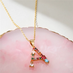 Macro shot of gold letter A pendant necklace with colorful cubic zirconia inlays
