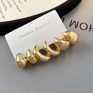 Three pairs of Chunky C-shape golden hoop earrings on a display card for women