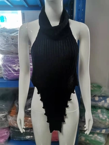 Dettaglio del top a dolcevita in maglia nera con orlo a triangolo asimmetrico su manichino