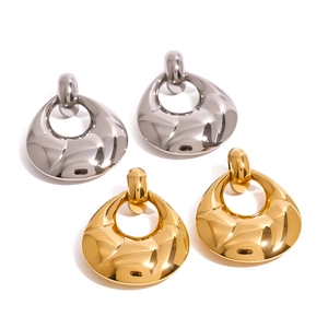 Boucles d'oreilles gouttes d'eau ondulées en or et argent sur fond blanc pur