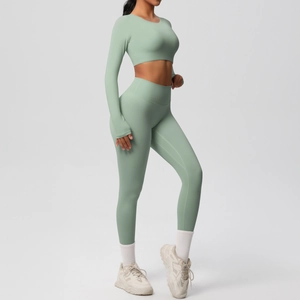 Close-up of mint green high-waisted yoga leggings and long sleeve crop top fitness set