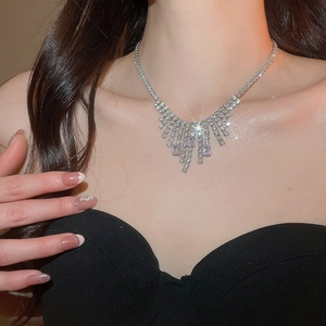 Macro shot of silver zircon fringe necklace on model showing luxury tassel details