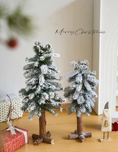 Macro detail of mini flocked Christmas trees with white snow effect and wooden bases