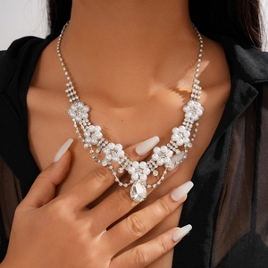 Detailed view of rhinestone flower sweater chain with drop pendant and imitation pearls