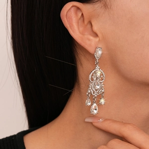 Detail of luxury silver waterdrop earrings with multilayered sparkling crystals on model