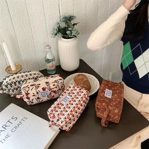 Détail de quatre trousses de toilette en velours côtelé aux motifs floraux vintage