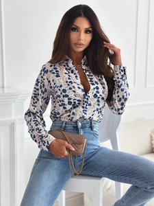 Detail of long sleeve slim blouse with cream and blue leopard print and denim pants